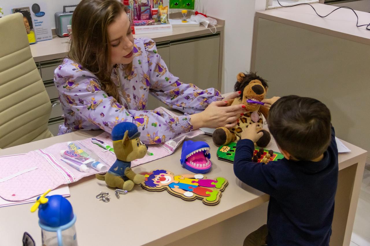 Dra. Luhana brincando na mesinha com a criança